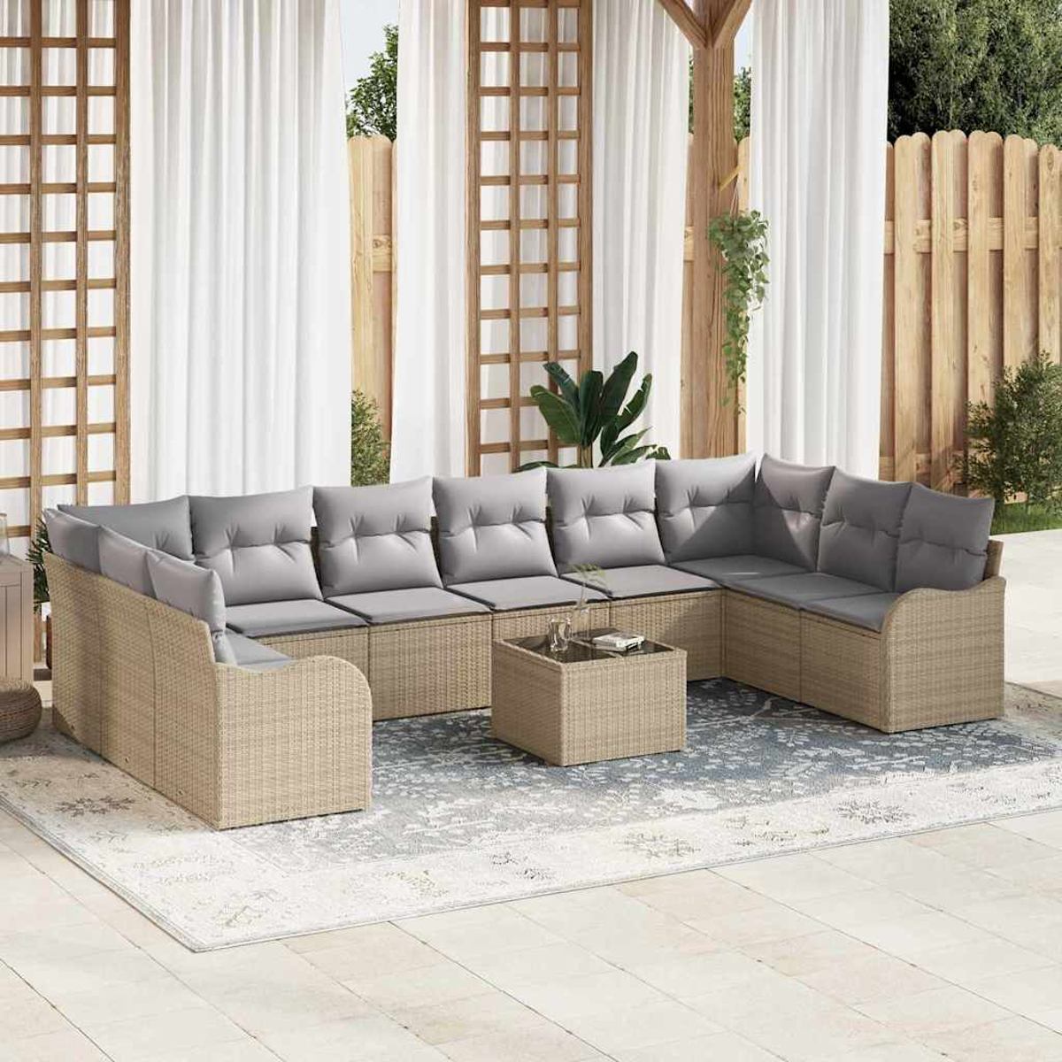 Outdoor-Ecksofa mit grauen Kissen auf einem Teppich. Weiße Vorhänge, Holzgitter und ein Zaun sind im Hintergrund.