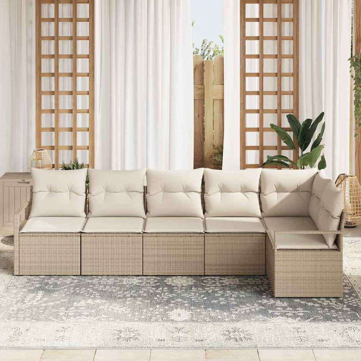 Ein Ecksofa im Freien mit cremefarbenen Kissen steht auf einem gemusterten Teppich. Weiße Vorhänge und Holzgitter im Hintergrund.
