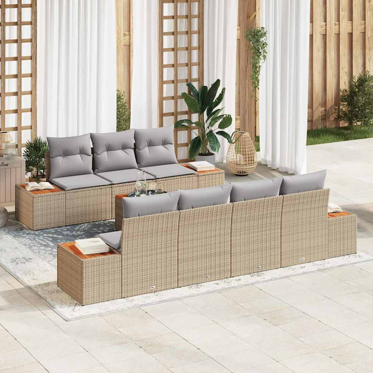 Garten-Terrassenset mit grauen Kissen und hölzernen Beistelltischen. Ein Teppich und Pflanzen sind im Hintergrund. Weiße Vorhänge und Holzzaun.