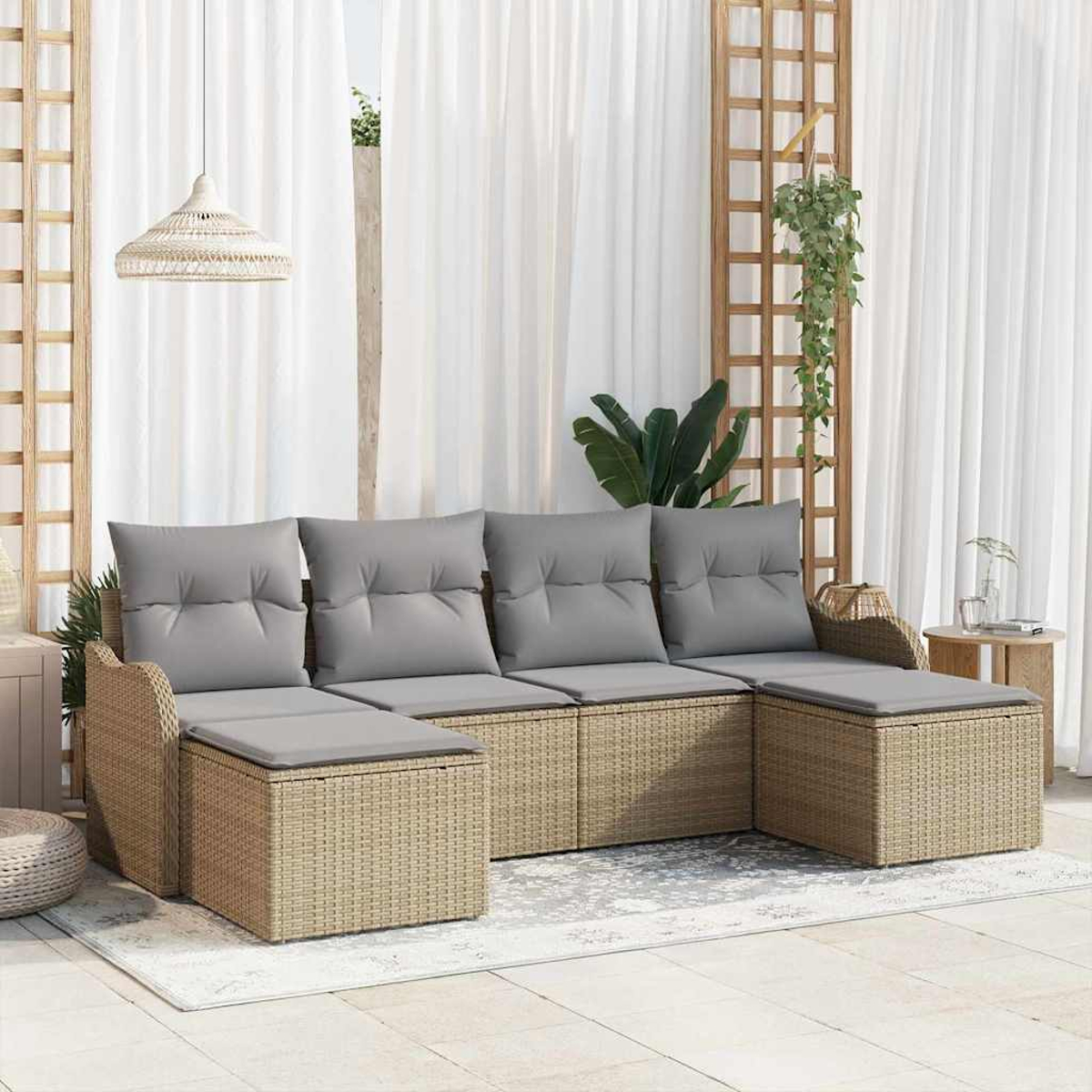 Ein Ecksofa mit grauen Kissen befindet sich auf einer Terrasse. Weiße Vorhänge und ein Holzgitter bilden den Hintergrund.