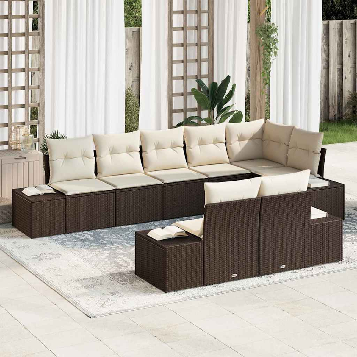 Outdoor-Ecksofa mit cremefarbenen Kissen, auf einem Teppich, vor weißen Vorhängen. Ein Buch liegt auf den Beistelltischen.