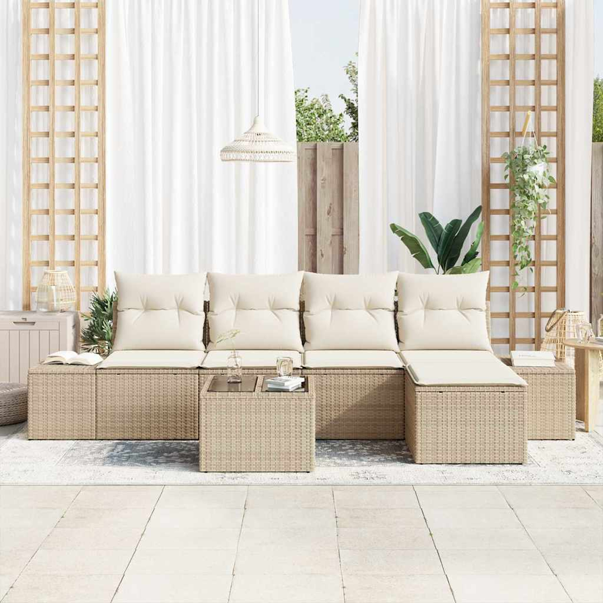 Gartenmöbel-Set. Beiges Korbmöbel mit weißen Kissen. Passender Tisch. Weiße Vorhänge und Holzgitter.