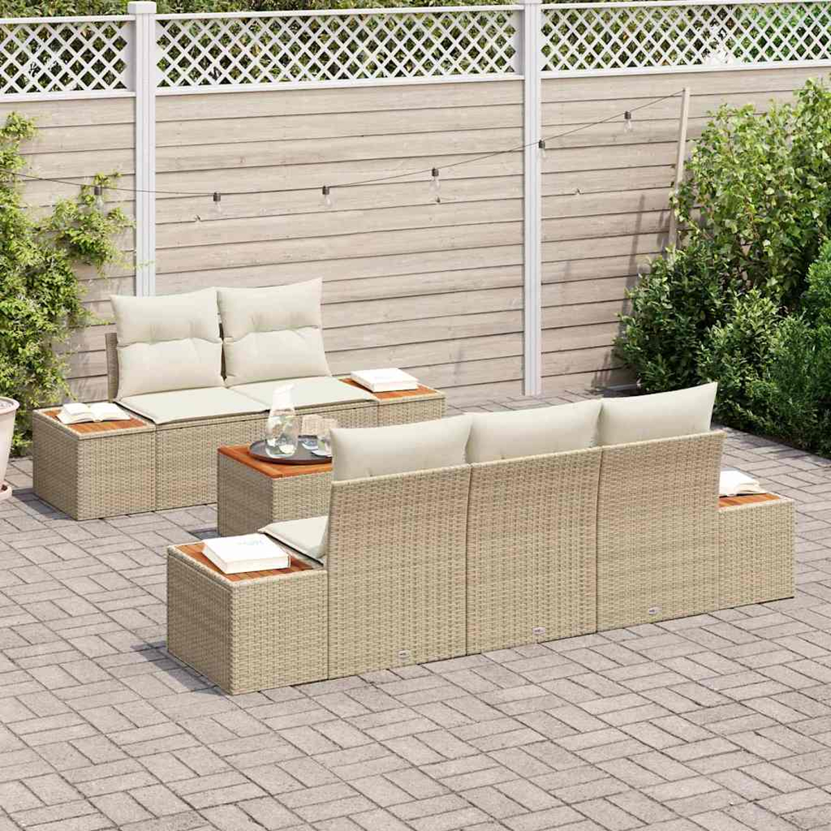 Juego de muebles de patio al aire libre en un patio de ladrillos. Incluye un sofá, dos sillas y una mesa pequeña con bebidas. Valla blanca en el fondo.