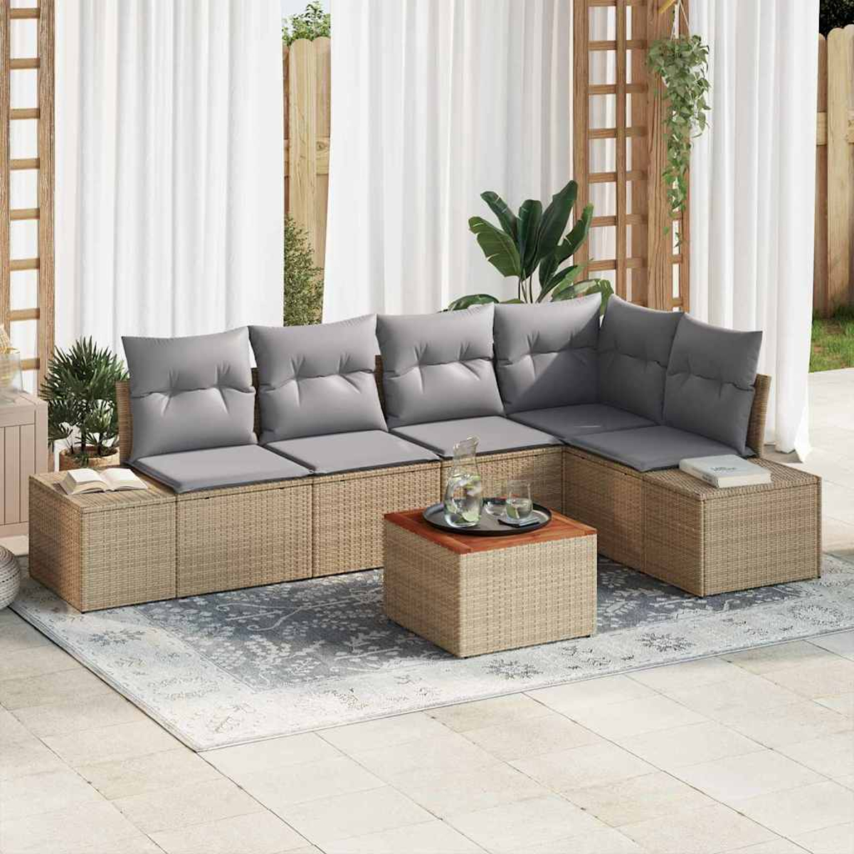 Geflochtenes Outdoor-Ecksofa mit grauen Kissen, Couchtisch mit Getränken und Teppich auf einer Terrasse mit weißen Vorhängen.
