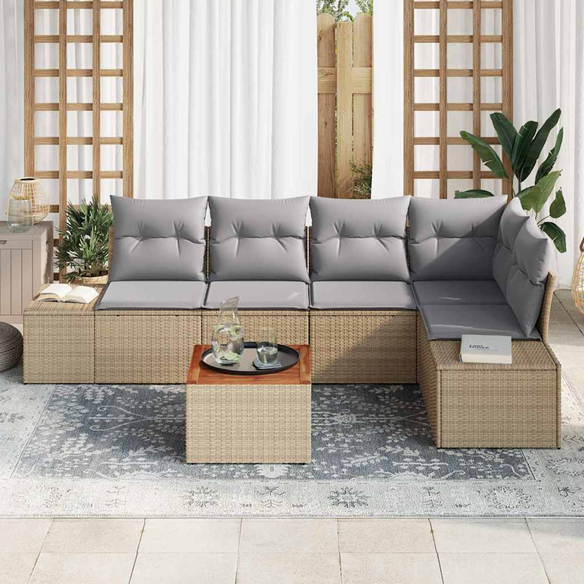 Outdoor-Ecksofa mit grauen Kissen. Ein Holztisch mit Tablett. Unter dem Sofa liegt ein gemusterter Teppich.