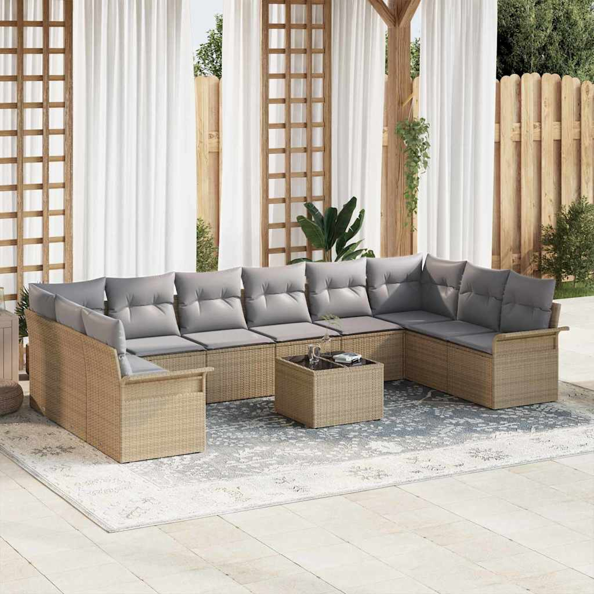 Ecksofa im Freien mit grauen Kissen auf einer Terrasse. Enthält einen Couchtisch und einen Teppich. Der Hintergrund hat Vorhänge und einen Zaun.