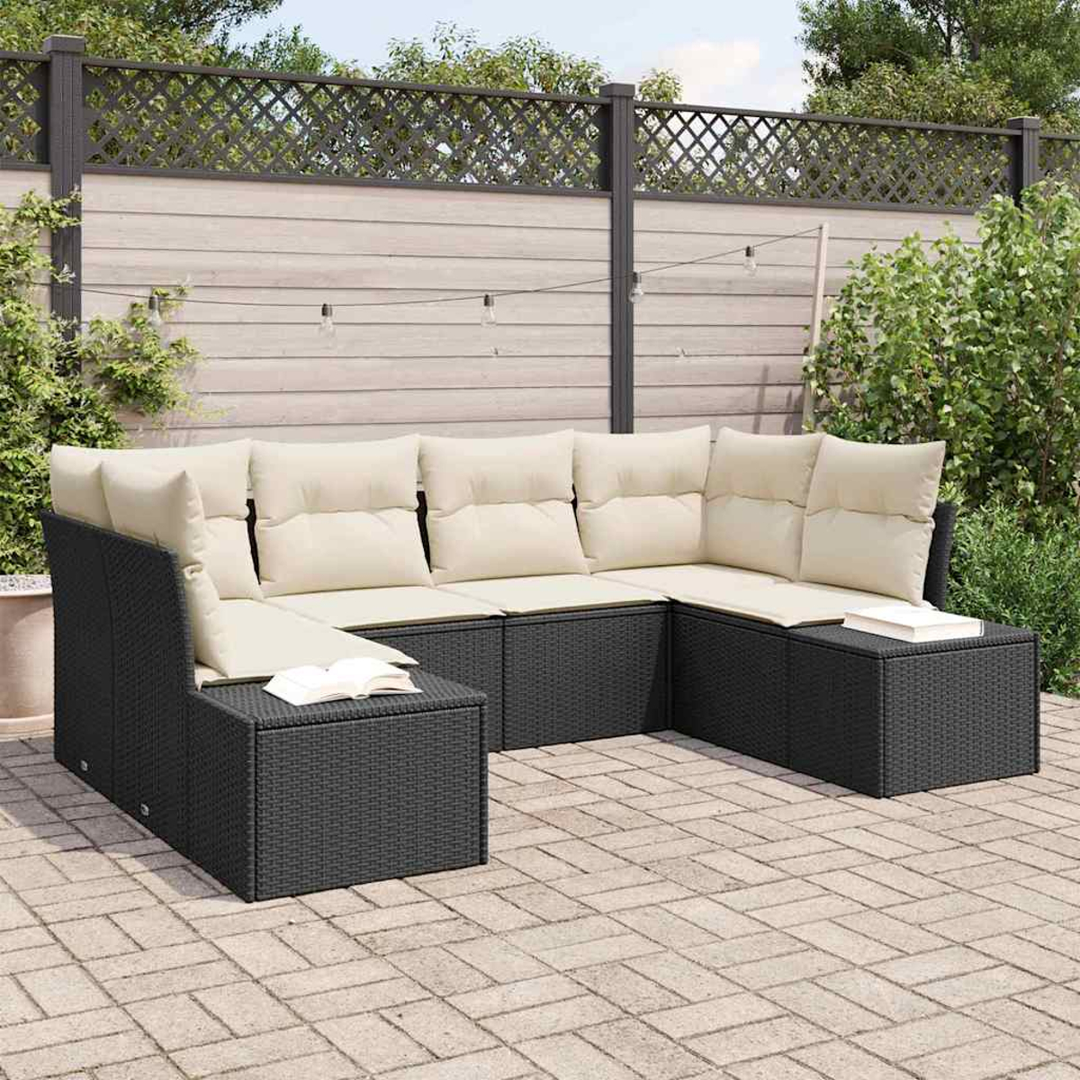 Schwarzes Outdoor-Sofa aus Korbgeflecht mit beigen Kissen. Auf dem Hocker liegt ein Buch. Im Hintergrund ein Holzzaun und Grün.