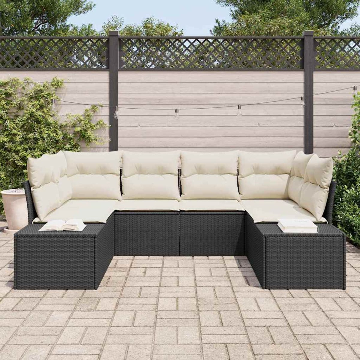 Ein schwarzes Outdoor-Sofa aus Korbgeflecht mit cremefarbenen Kissen steht auf einer Steinterrasse. Im Hintergrund sind ein Zaun und Grün.