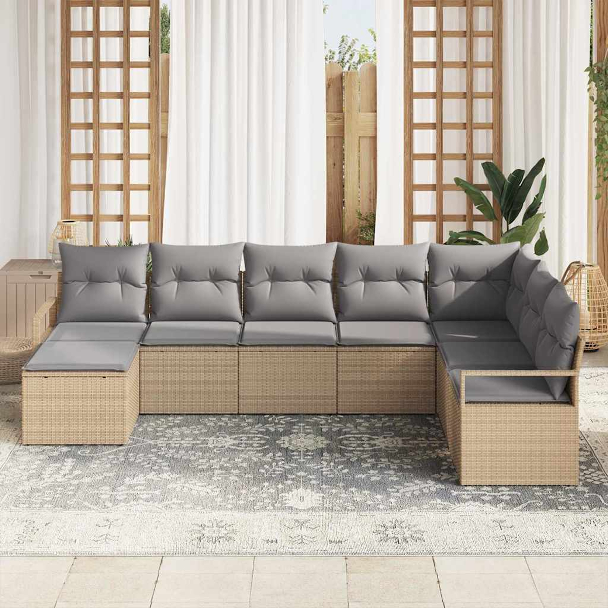 Outdoor-Ecksofa mit grauen Kissen. Beiger gewebter Sockel auf einem gemusterten Teppich. Hintergrund: Vorhänge, Holzgitter und Grün.
