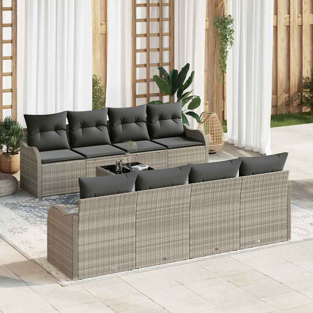 Terrassenmöbel-Set mit grauen Kissen. Enthält ein Sofa, eine Chaiselongue und einen Couchtisch. Hintergrund mit Vorhängen und Pflanzen.