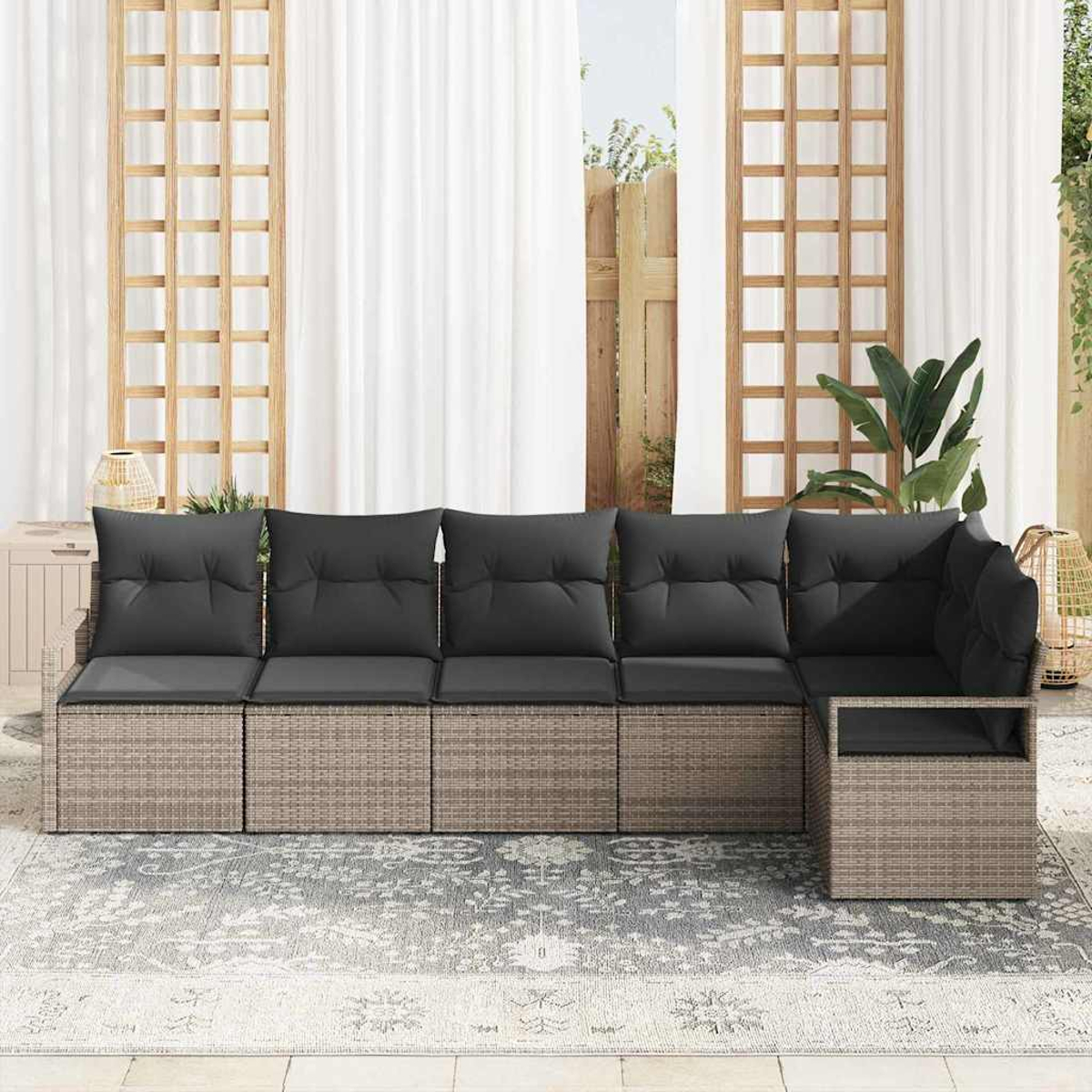 Outdoor-Ecksofa mit grauen Kissen auf einem gemusterten Teppich. Weiße Vorhänge und Holzgitter im Hintergrund. Pflanzen und ein dekorativer Korb.