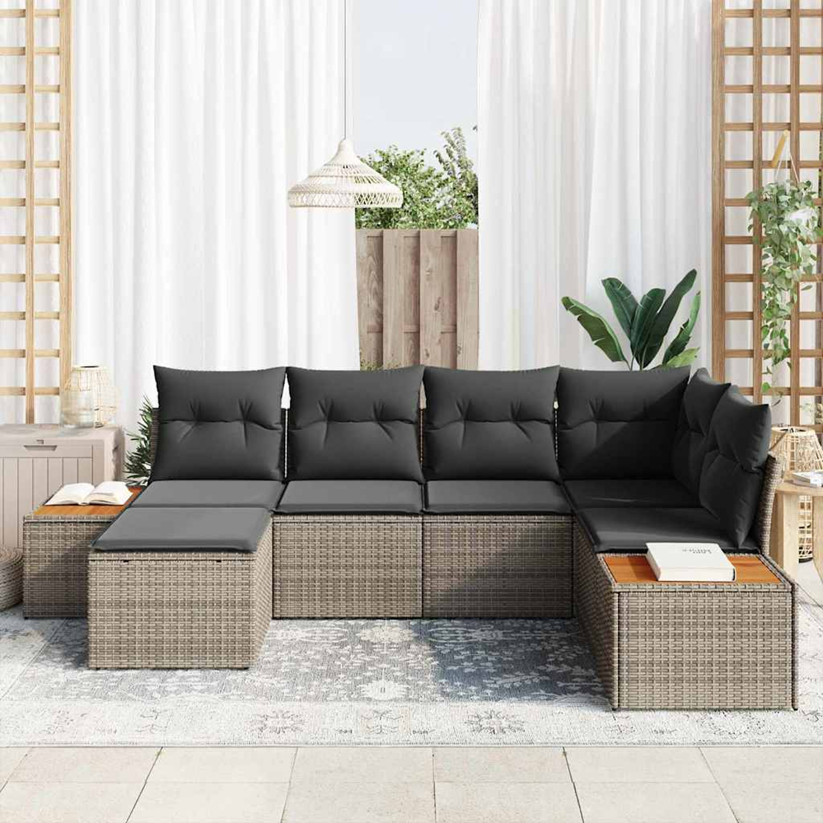 Outdoor-Ecksofa mit grauen Kissen auf einer Terrasse. Inklusive Teppich, hölzernen Beistelltischen und weißen Vorhängen.