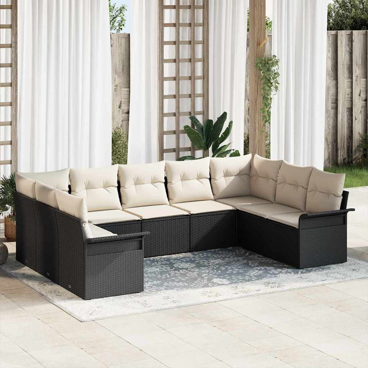 Ein Ecksofa im Freien mit beigen Kissen steht auf einem gemusterten Teppich. Weiße Vorhänge und Holzkonstruktionen bilden den Hintergrund.