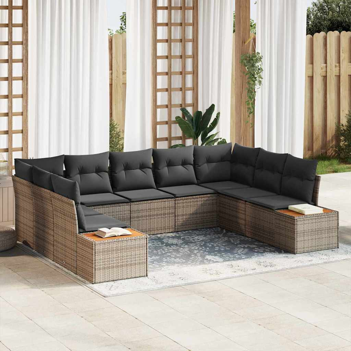 Ein Outdoor-Ecksofa mit grauen Kissen steht auf einer Terrasse. Weiße Vorhänge und ein Holzzaun sind im Hintergrund.