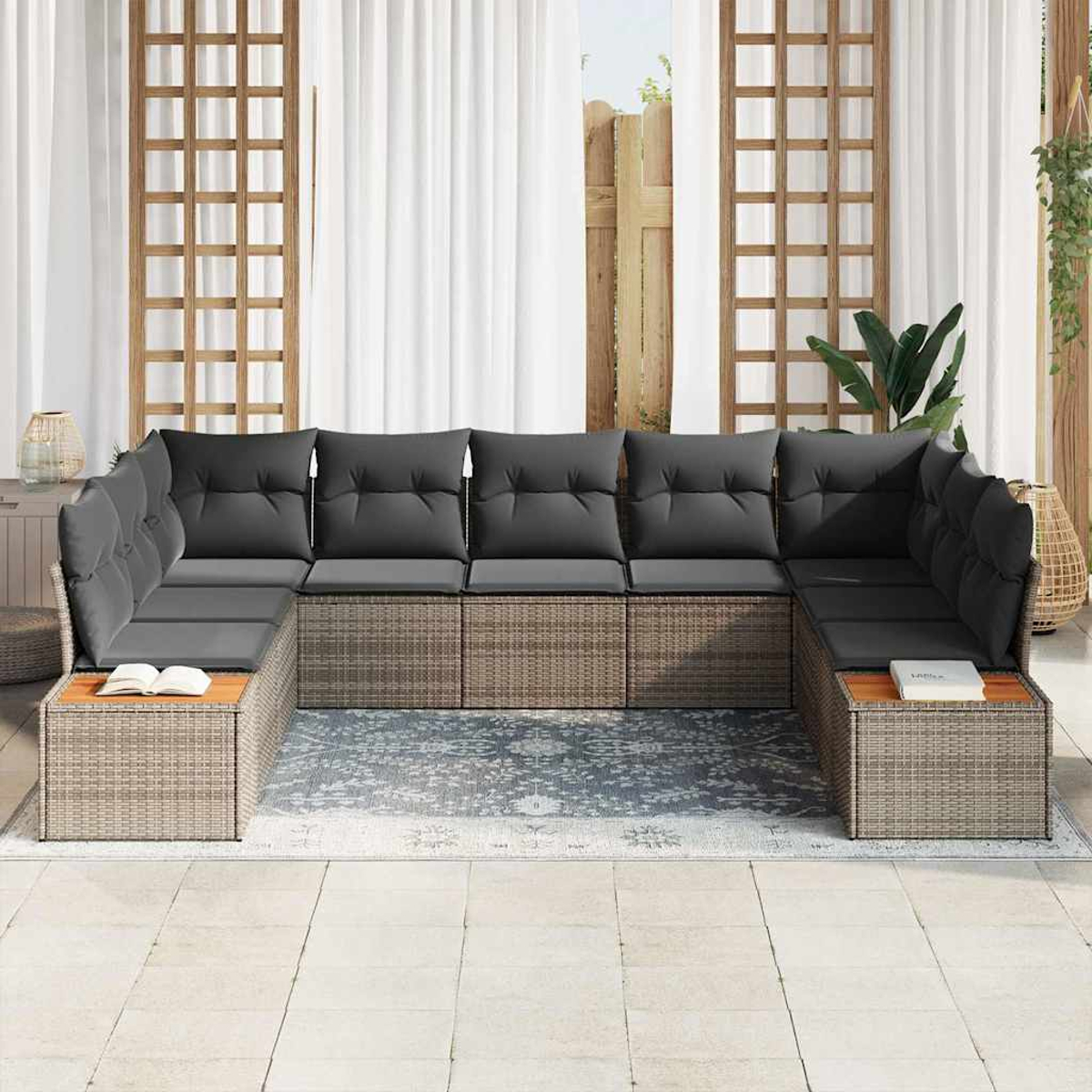 U-förmiges Outdoor-Sofa mit grauen Kissen. Es hat eine hellbraune gewebte Basis, einen hölzernen Beistelltisch und steht auf einem gemusterten Teppich.