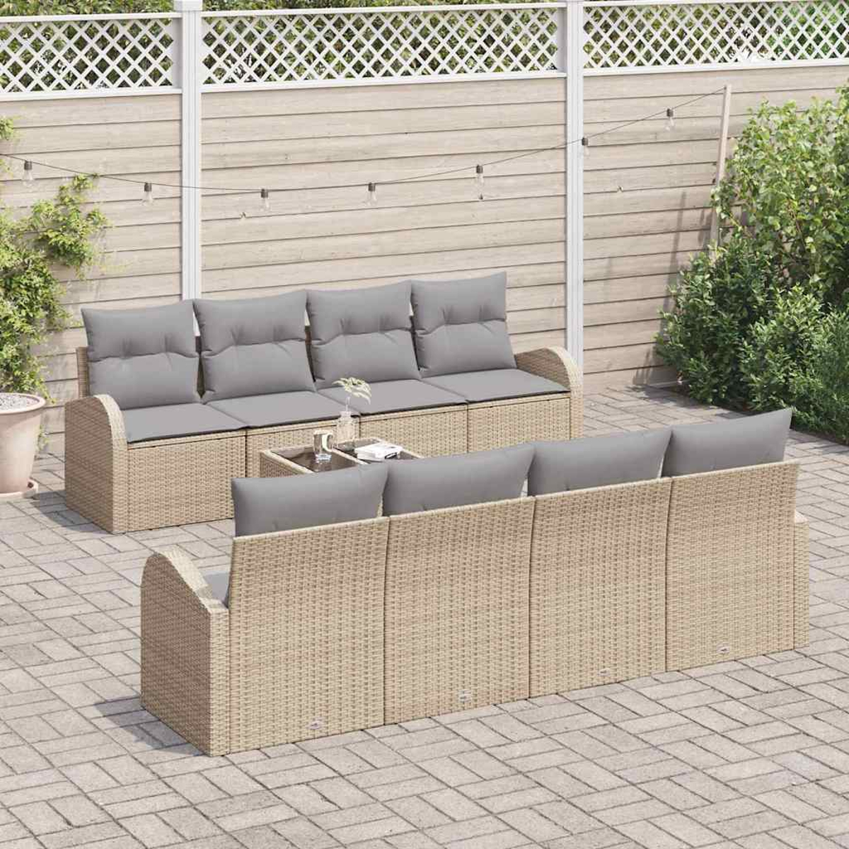 Terrassenset mit hellbraunen Korbsesseln, grauen Kissen und einem Tisch mit Glasplatte auf einer Ziegelterrasse mit Holzzaun.
