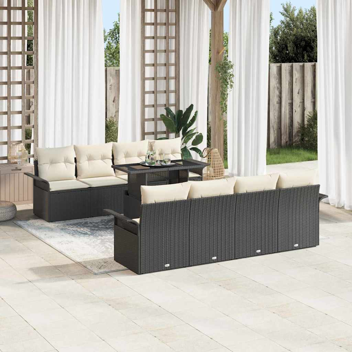 Terrassenset im Freien mit grauen Korbmöbeln und cremefarbenen Kissen, einem Tisch und weißen Vorhängen. Die Szene spielt im Freien.