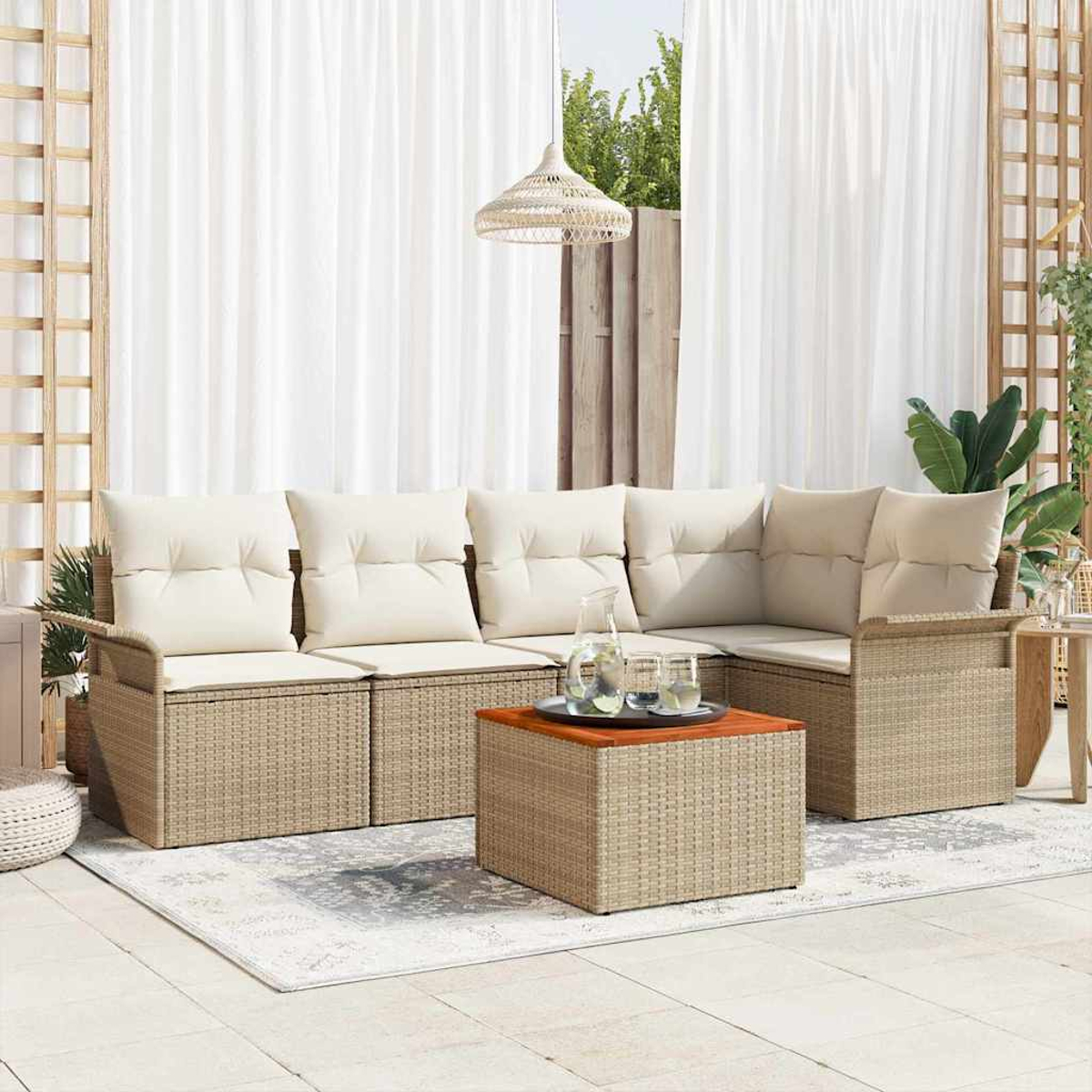 Outdoor-Ecksofa mit cremefarbenen Kissen. Couchtisch mit Getränken. Weiße Vorhänge im Hintergrund. Korblampe und Teppich.