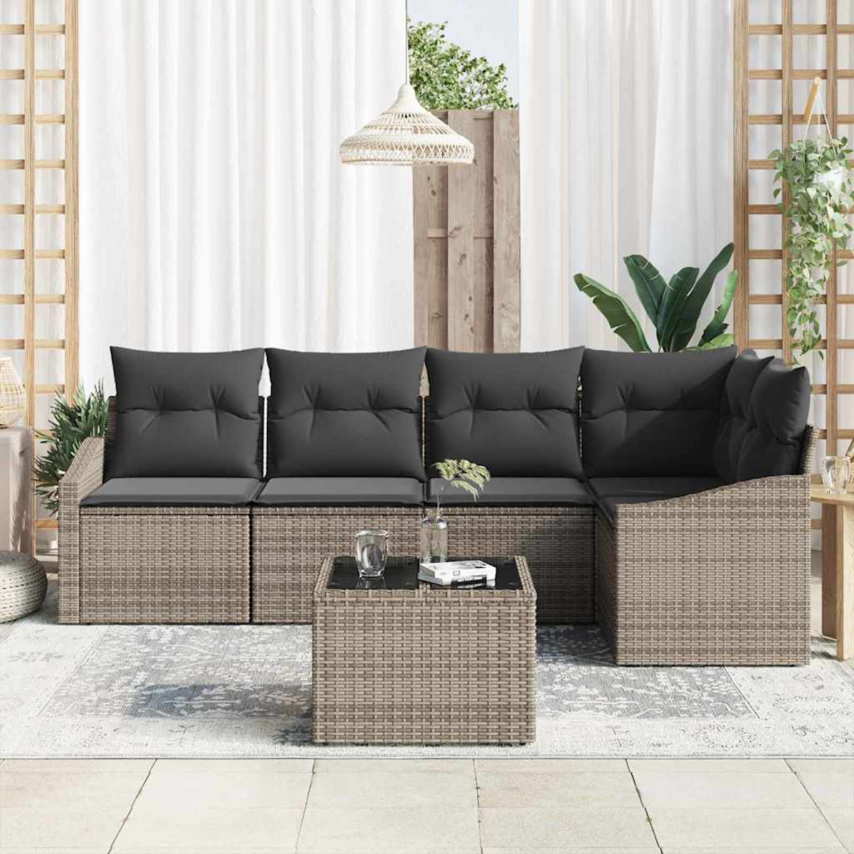 Outdoor-Ecksofa mit grauen Kissen und einem kleinen Tisch. Weiße Vorhänge und eine Hängeleuchte vervollständigen die Szene.