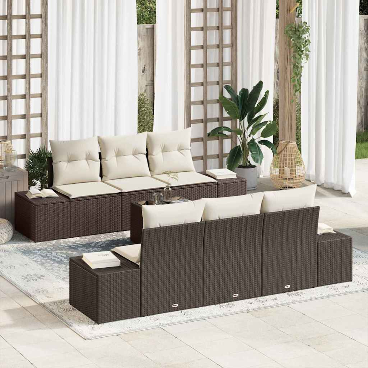 Conjunto de asientos al aire libre con sofás de mimbre marrón, cojines crema, plantas y cortinas blancas. El escenario es un patio.