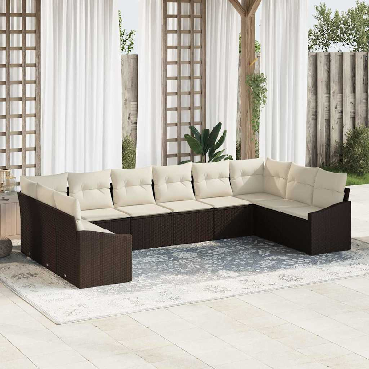 Ein Ecksofa im Freien mit cremefarbenen Kissen steht auf einem Teppich. Weiße Vorhänge, Holzgitter und ein Zaun sind im Hintergrund.