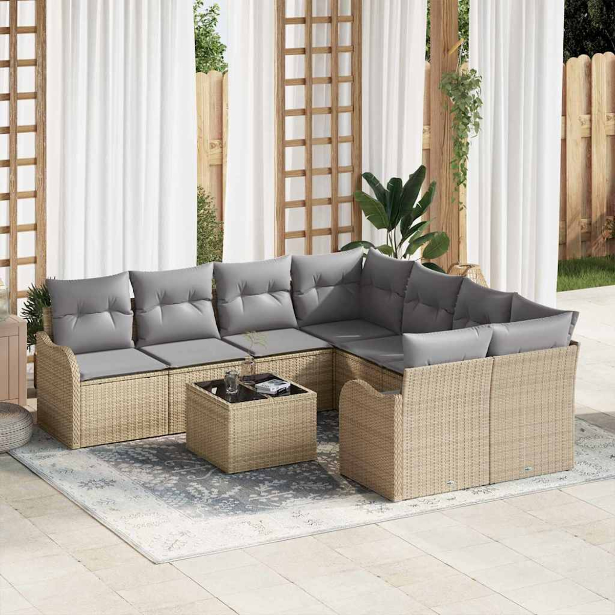 Outdoor-Ecksofa mit grauen Kissen und Couchtisch auf einem Teppich. Hintergrund: Vorhänge, Holzkonstruktion und Pflanzen.