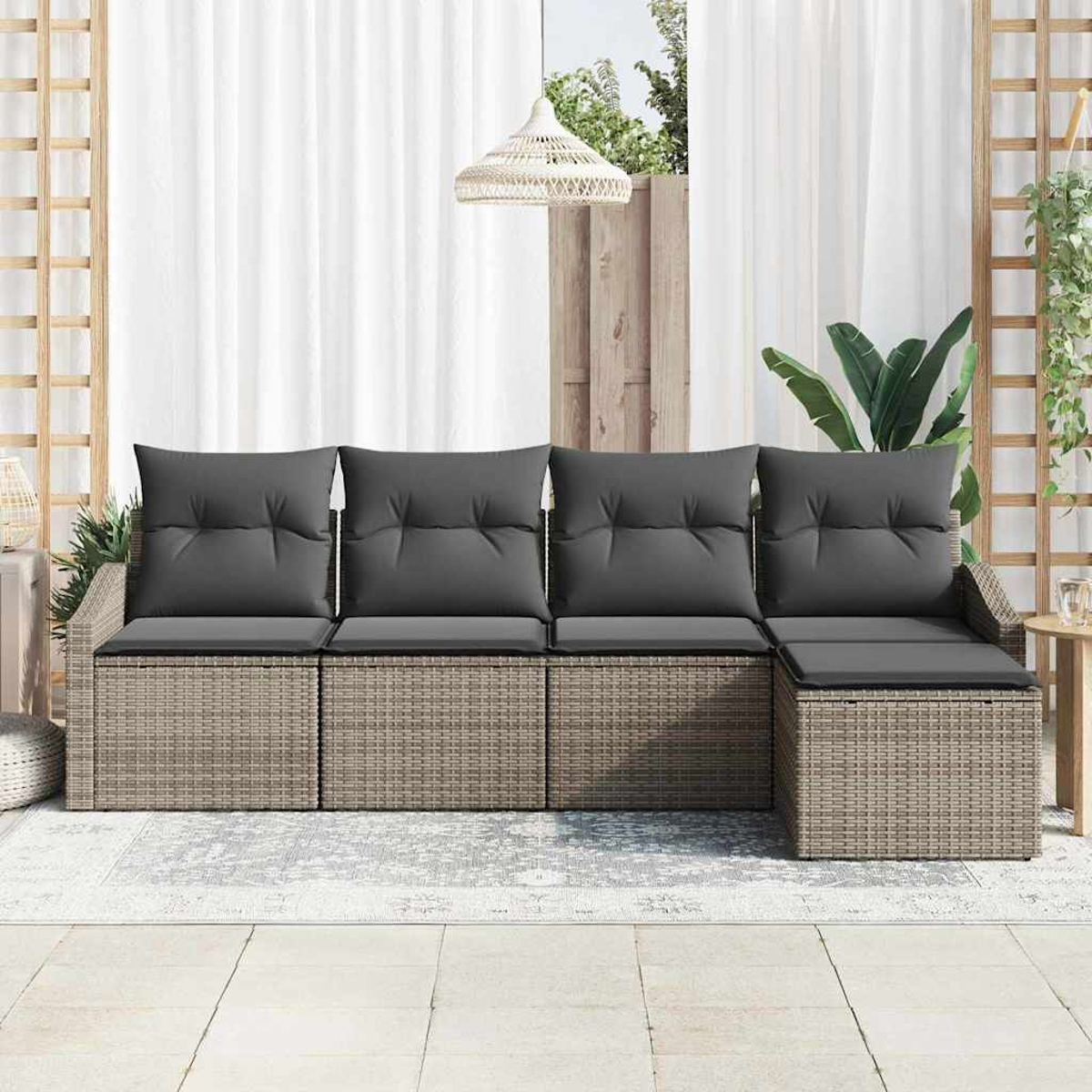 Outdoor-Ecksofa mit grauen Kissen und gewebtem Korbgeflecht. Es steht auf einer Terrasse mit weißen Vorhängen und einer Hängeleuchte.