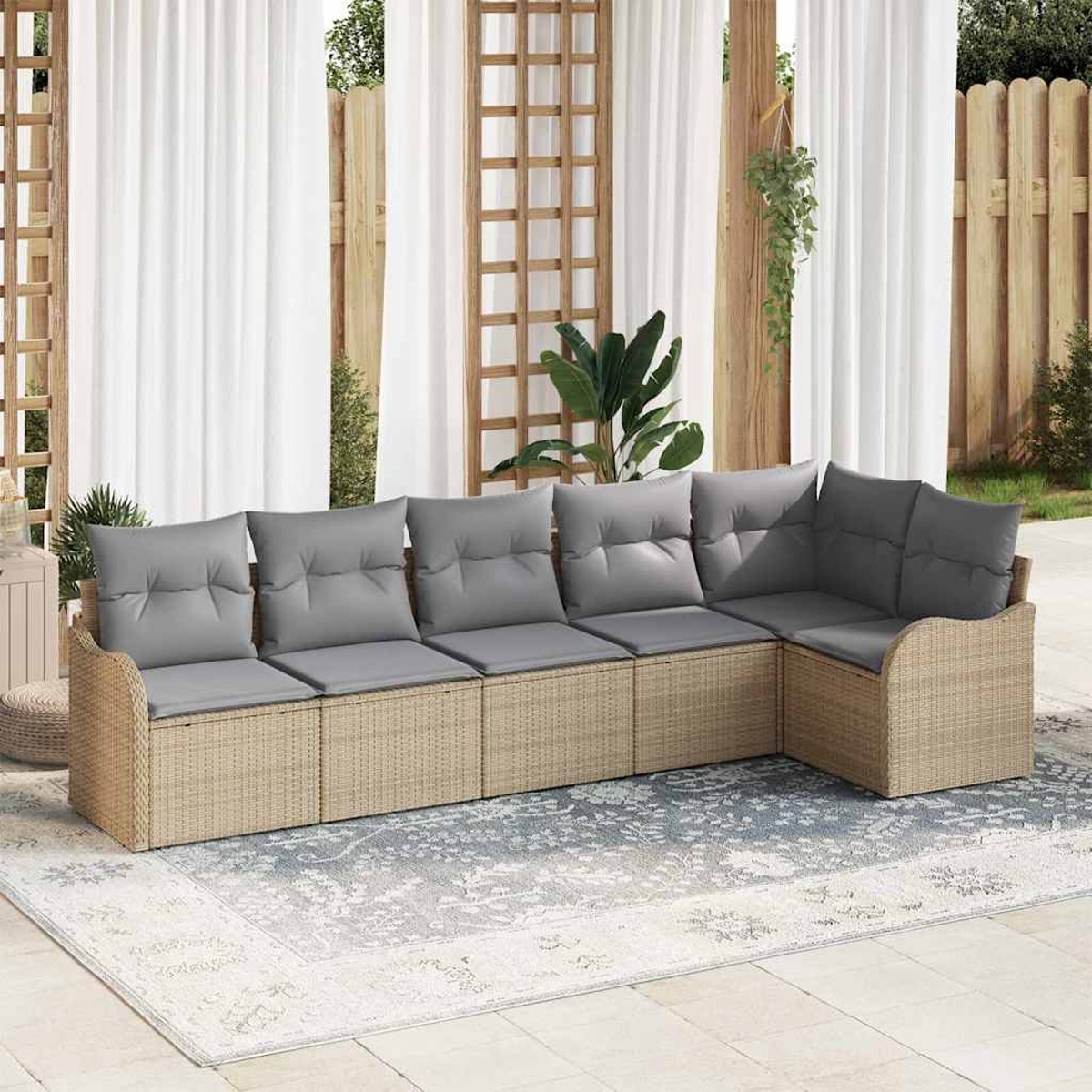 Ein Ecksofa mit grauen Kissen steht auf einem gemusterten Teppich. Weiße Vorhänge und ein Holzgitter sind im Hintergrund.