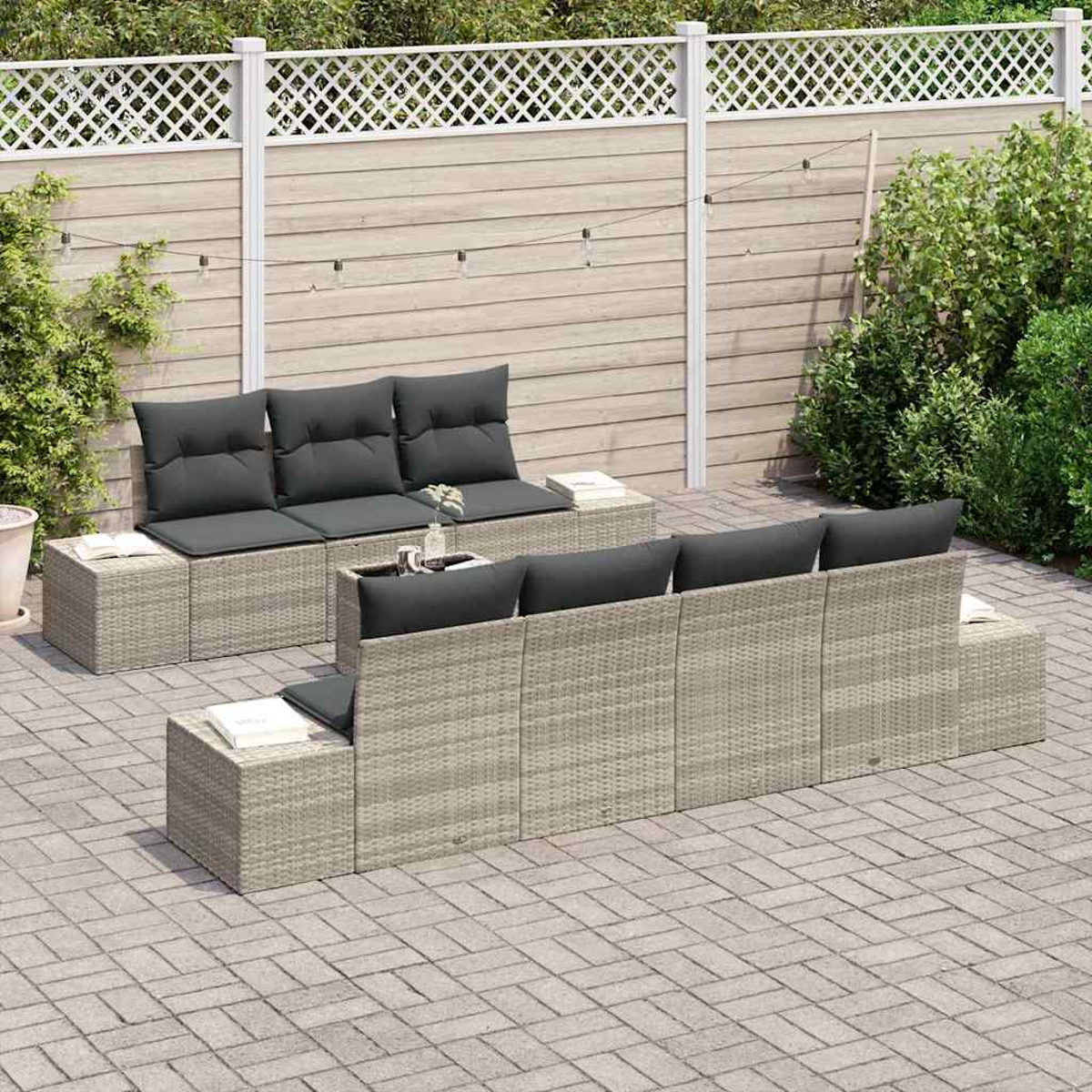 Outdoor-Korbmöbel-Set mit grauen Kissen auf einer Terrasse. Ein weißer Zaun und Grünzeug im Hintergrund.