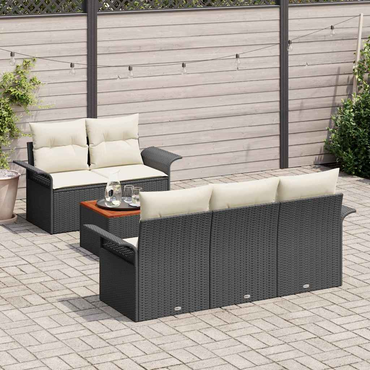 Ein Terrassenset mit einem dunkelgrauen Korbmöbel-Sofa und -Liebesitz mit cremefarbenen Kissen, einem Couchtisch und einem grauen Holzzaun im Hintergrund.