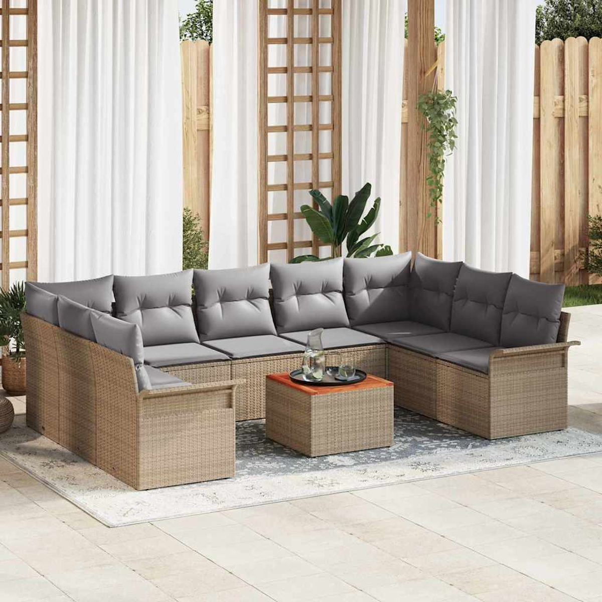 Outdoor-Ecksofa mit grauen Kissen und einem kleinen Tisch auf einer Terrasse, mit weißen Vorhängen und Holzzaun im Hintergrund.