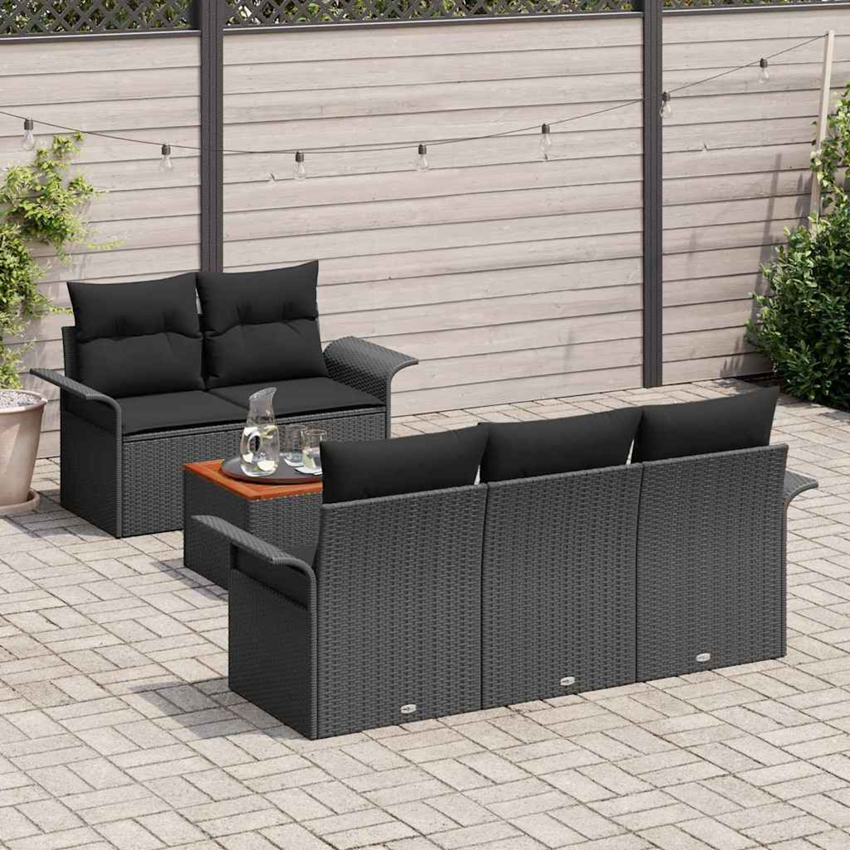 Garten-Terrassenset mit dunkelgrauen Korbmöbeln, schwarzen Kissen und einem kleinen Holztisch mit Getränken. Holzzaun im Hintergrund.