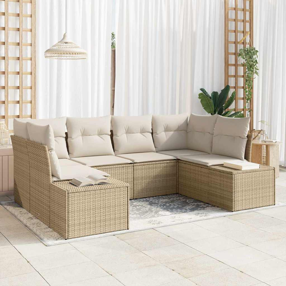 Beiges Korbsessel-Sofa mit cremefarbenen Kissen. Weiße Vorhänge, Holzgitter und eine Hängelampe. Ein Buch liegt auf dem Sofa.