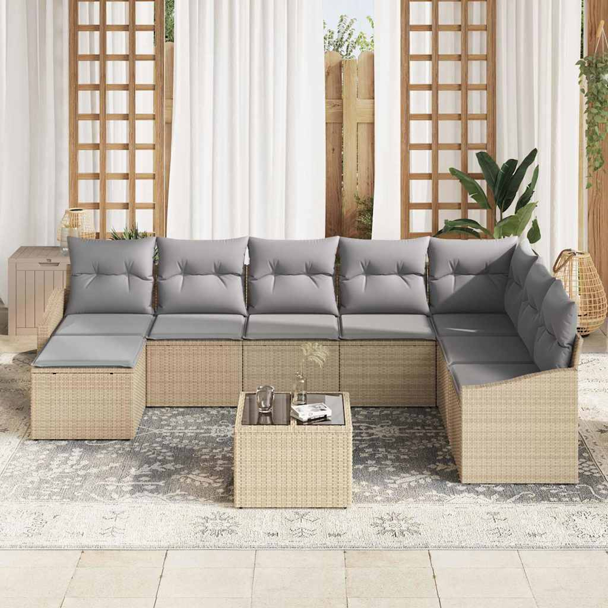 Garten-Ecksofa mit grauen Kissen, Korbtisch und Teppich. Der Hintergrund umfasst eine Terrasse, weiße Vorhänge und Grün.