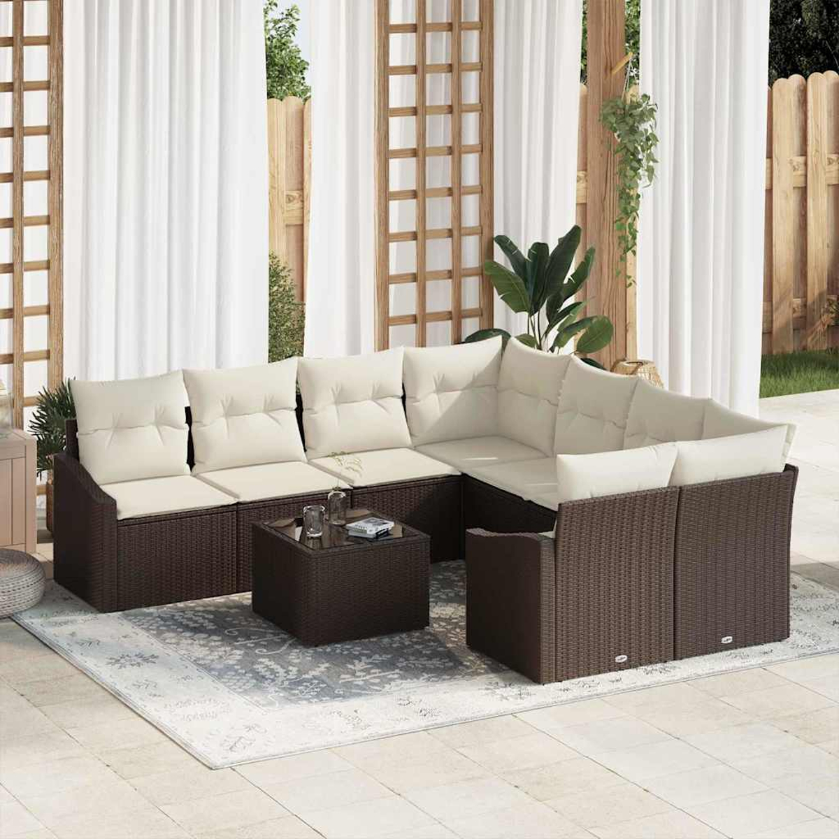 Ein braunes Outdoor-Ecksofa aus Korbgeflecht mit cremefarbenen Kissen und einem Couchtisch steht auf einem Teppich.