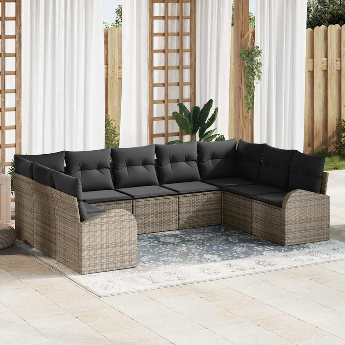 Ein Ecksofa mit grauen Kissen steht auf einem hellen Teppich. Weiße Vorhänge und ein Holzzaun sind im Hintergrund.