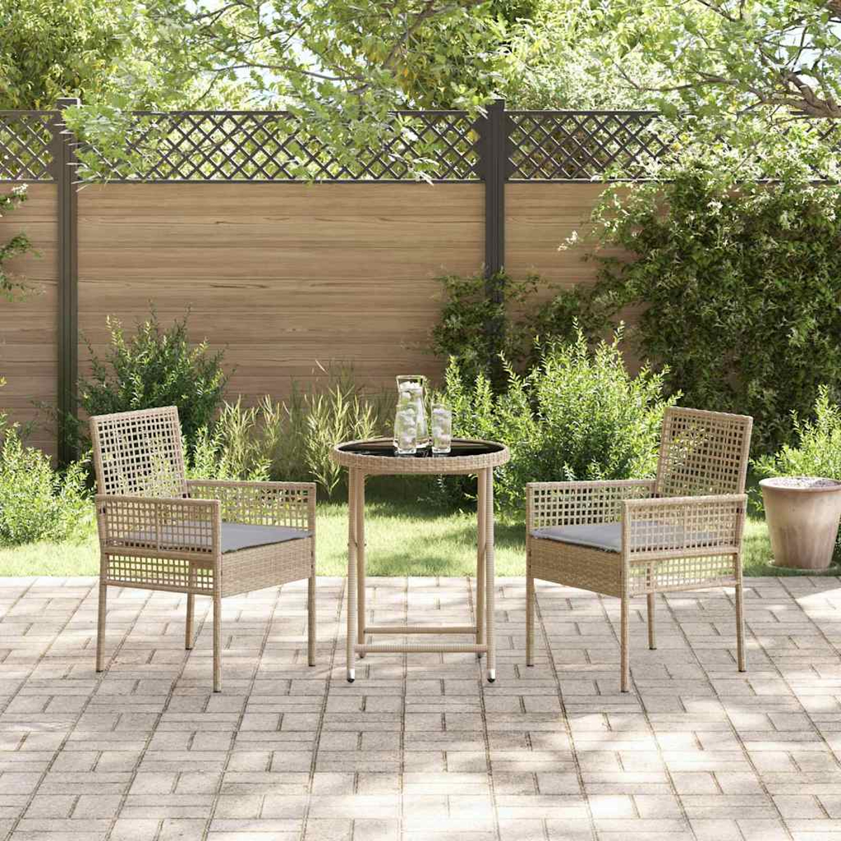 Szene im Freien mit zwei Stühlen, einem kleinen Tisch und einem Zaun. Stühle haben graue Kissen. Tisch hat zwei Gläser. Ziegel-Patio.