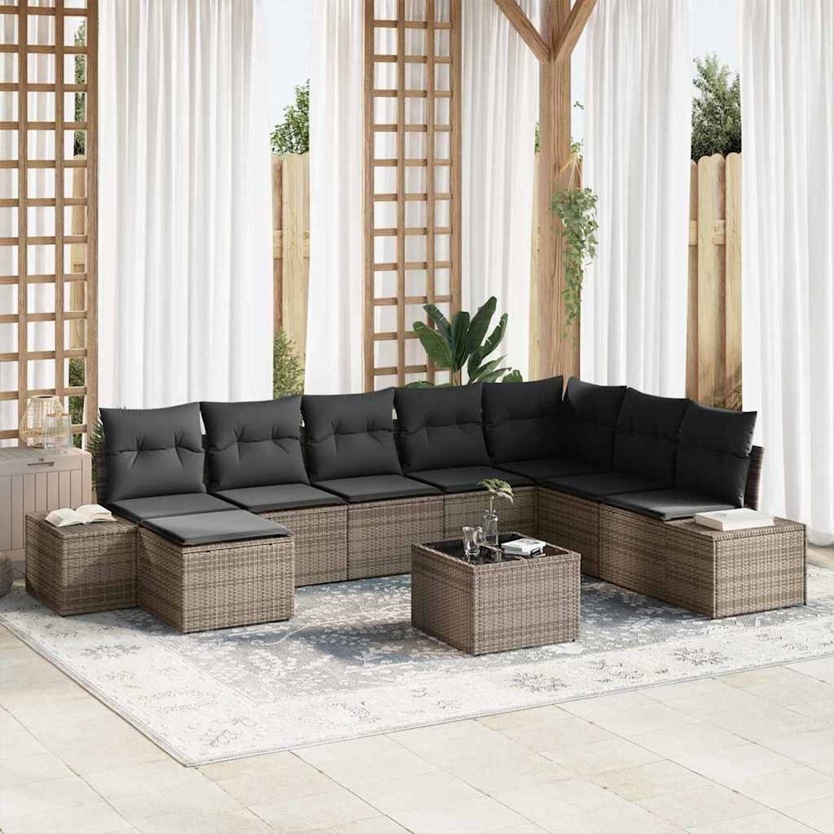 Ein Sitzbereich im Freien mit Ecksofa, Kissen und Couchtisch. Weiße Vorhänge und Holzgitter im Hintergrund.