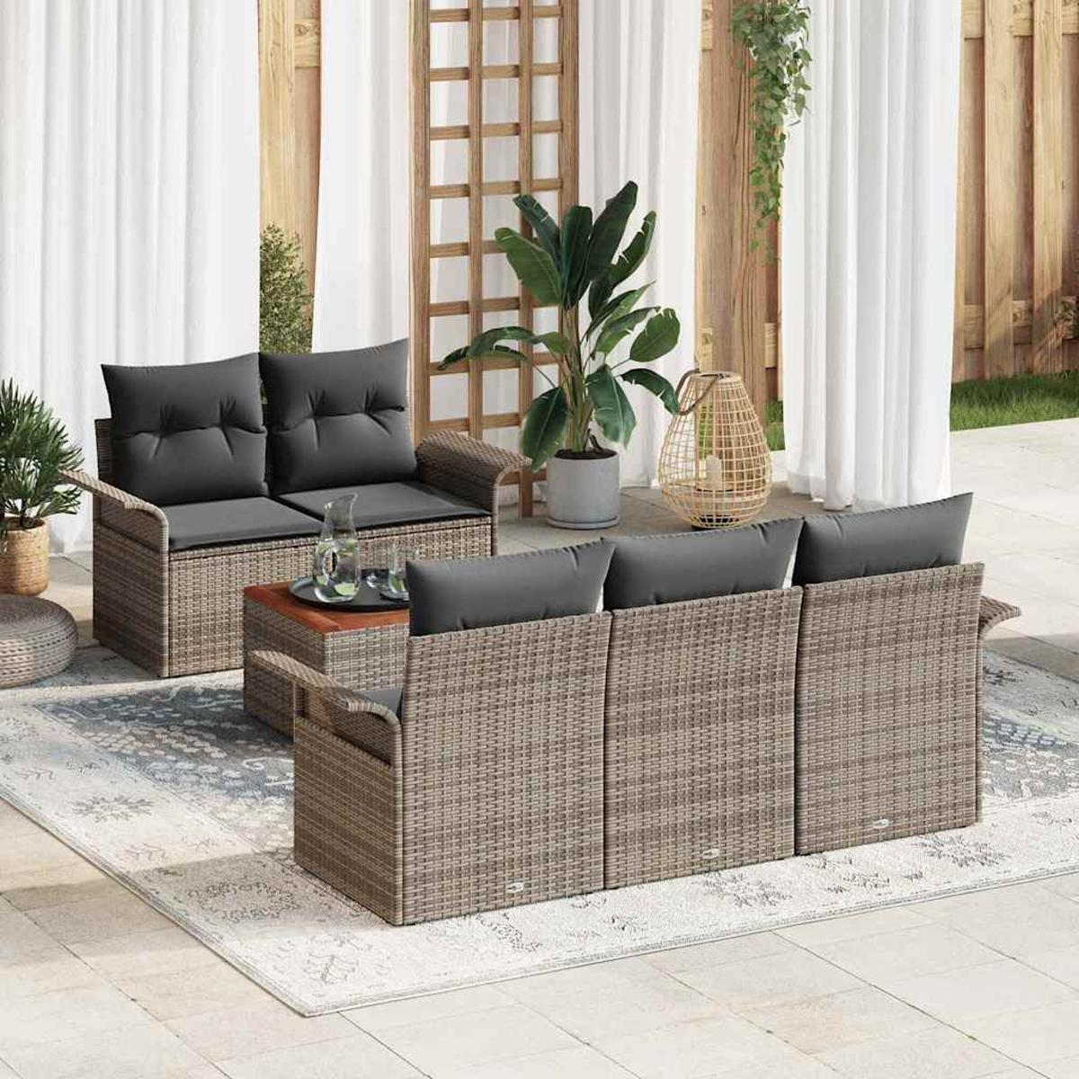 Garten-Set mit grauen Kissen. Enthält ein Zweisitzer, ein Sofa, einen Couchtisch und einen Teppich. Pflanzen und Vorhänge im Hintergrund.