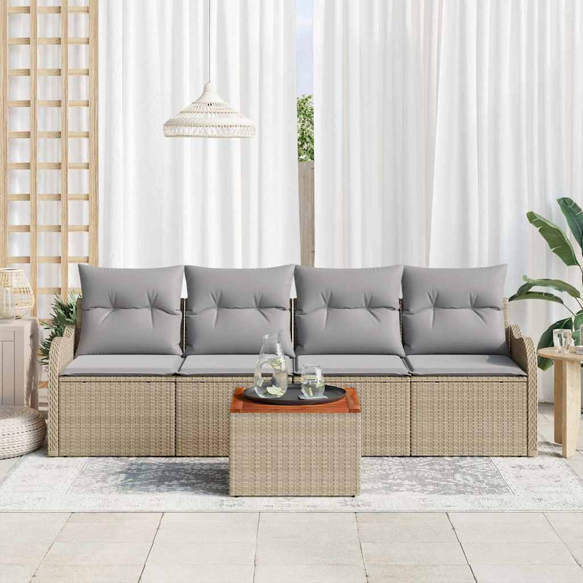 Ein Korbmöbel mit grauen Kissen, ein kleiner Tisch mit Getränken und ein weißer Vorhang im Hintergrund. Über dem Sofa hängt eine Hängelampe.