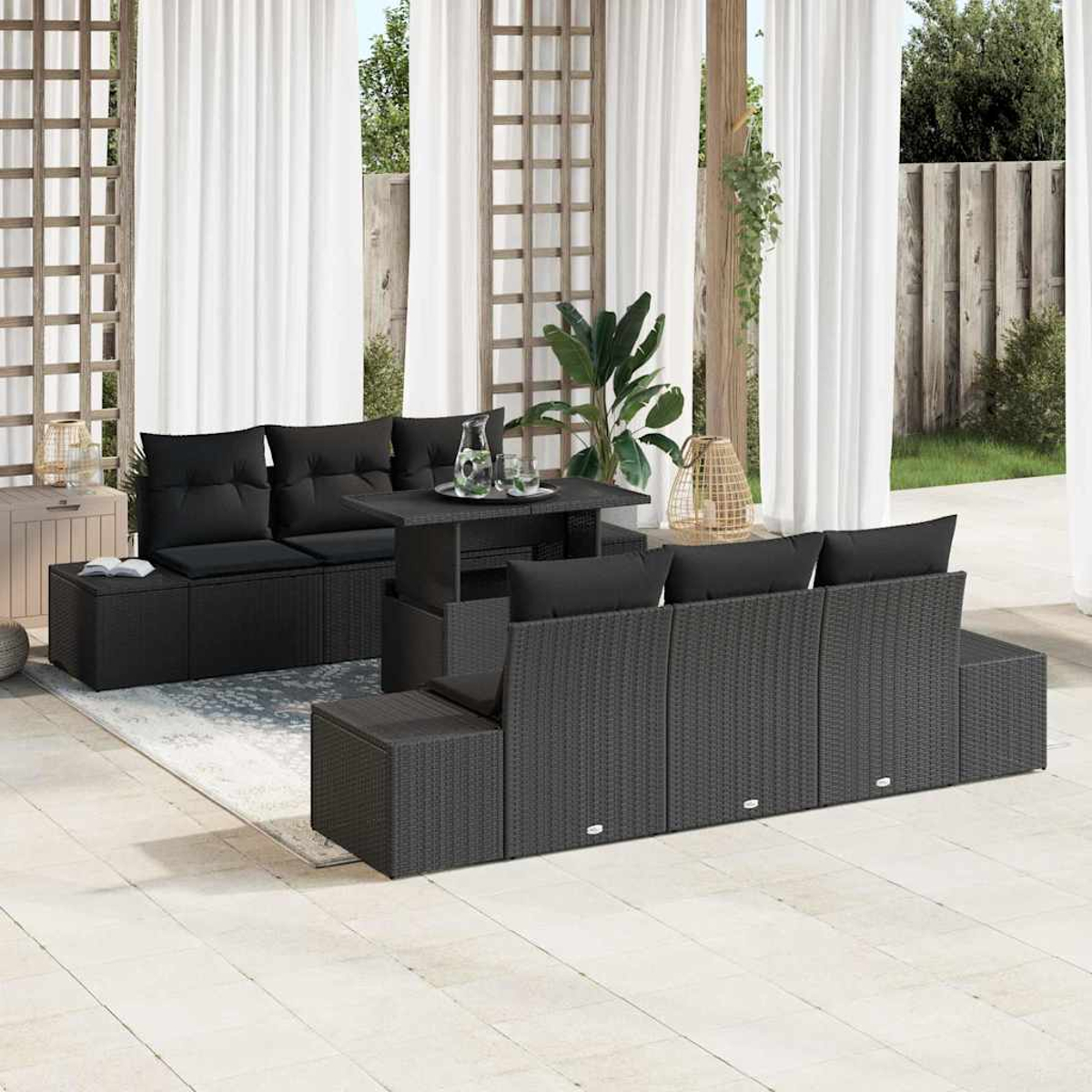 Outdoor-Terrassenmöbel mit schwarzen Korbmöbeln, einschließlich Tisch und Sofa. Weiße Vorhänge und ein Holzzaun im Hintergrund.