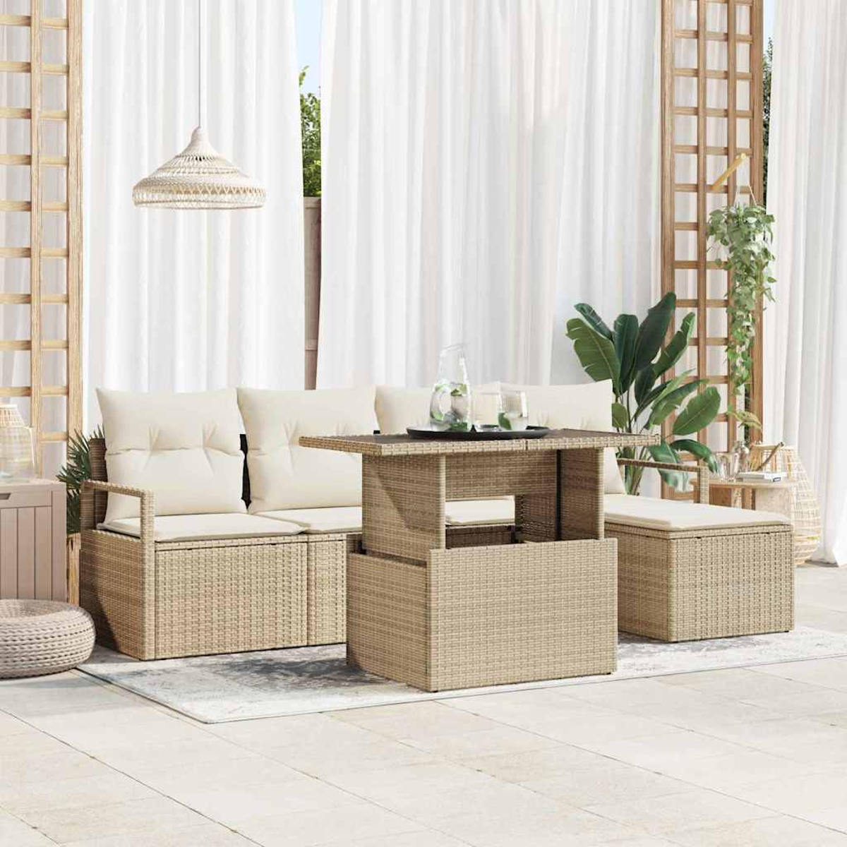 Außenwohnbereich mit Korbmöbeln, weißen Vorhängen und einer Hängeleuchte. Beinhaltet Sofa, Tisch, Ottoman und Pflanzen.