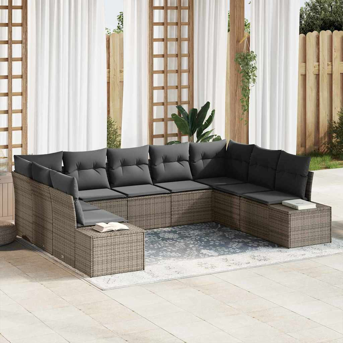 Ein U-förmiges Outdoor-Sofa mit grauen Kissen steht auf einer Terrasse. Vorhänge, Holzgitter und ein Zaun befinden sich im Hintergrund.