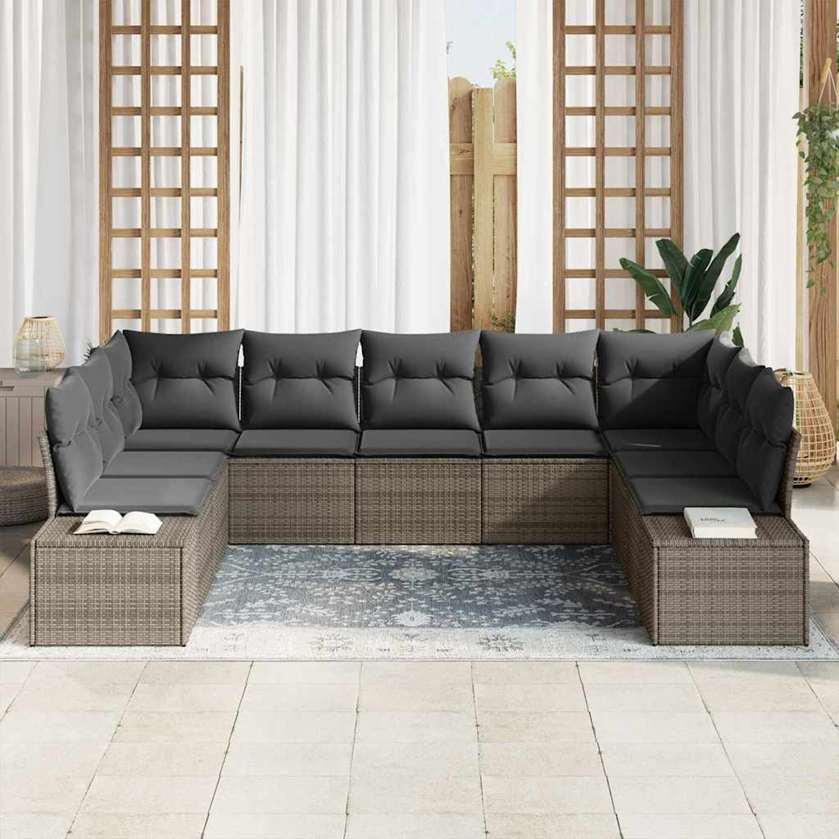 Outdoor-Ecksofa mit grauen Kissen. Rattangestell. Weiße Vorhänge und Holzgitter im Hintergrund.