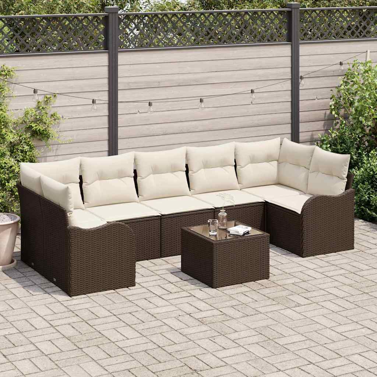 Gartencouch mit cremefarbenen Kissen und einem kleinen Tisch. Braune Korbmöbel auf einer gepflasterten Terrasse mit Zaun im Hintergrund.