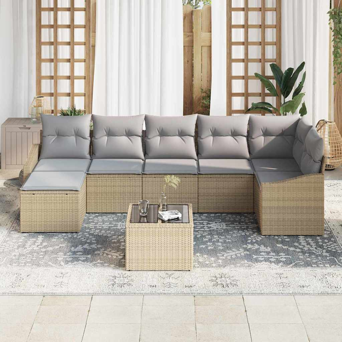 Outdoor-Ecksofa mit grauen Kissen, kleinem Glastisch und gemustertem Teppich. Hintergrund hat weiße Vorhänge und Holzgitter.