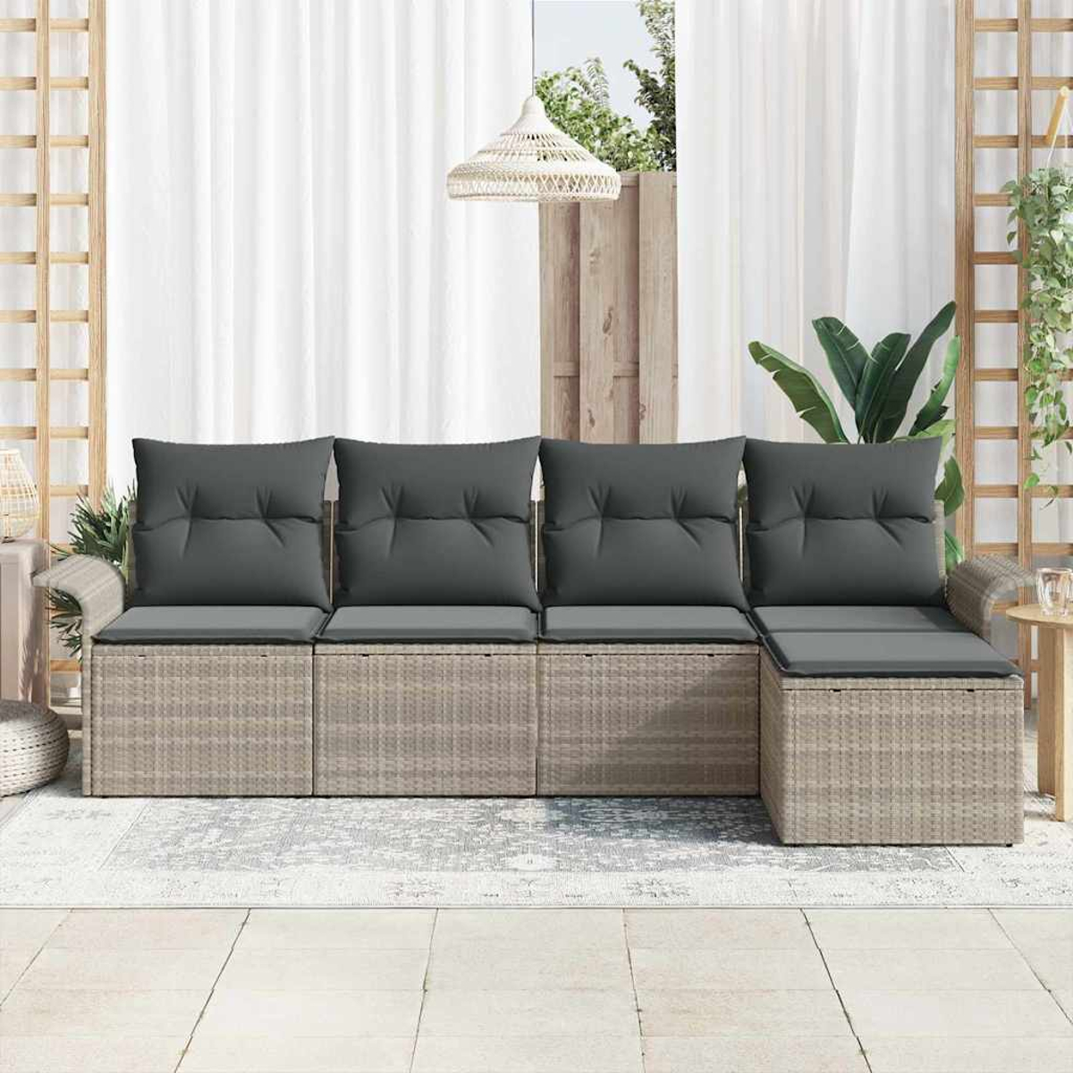 Outdoor-Ecksofa mit grauen Kissen und Weidenrahmen. Weiße Vorhänge und Holzgitter im Hintergrund, Teppich auf dem Boden.