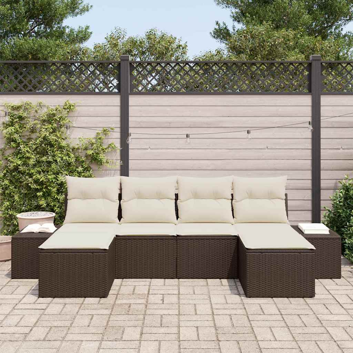 Outdoor-Ecksofa mit cremefarbenen Kissen und braunem Korbgeflecht. Auf einer Terrasse mit Holzzaun im Hintergrund.