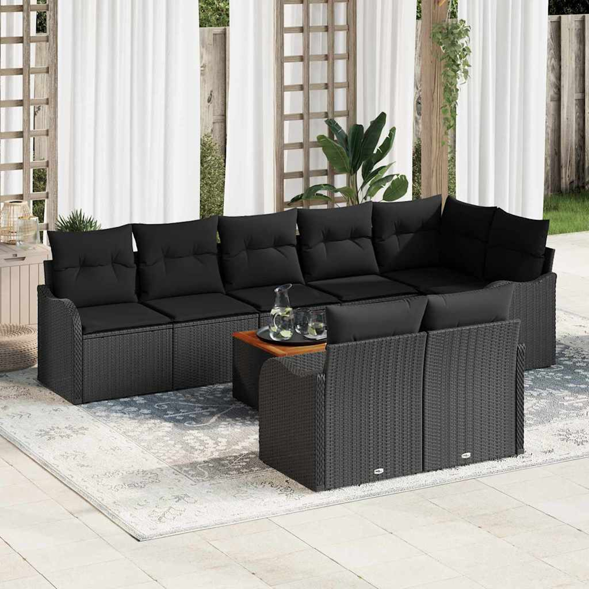 Outdoor-Ecksofa mit schwarzen Kissen, einem hölzernen Couchtisch und Vorhängen im Hintergrund.