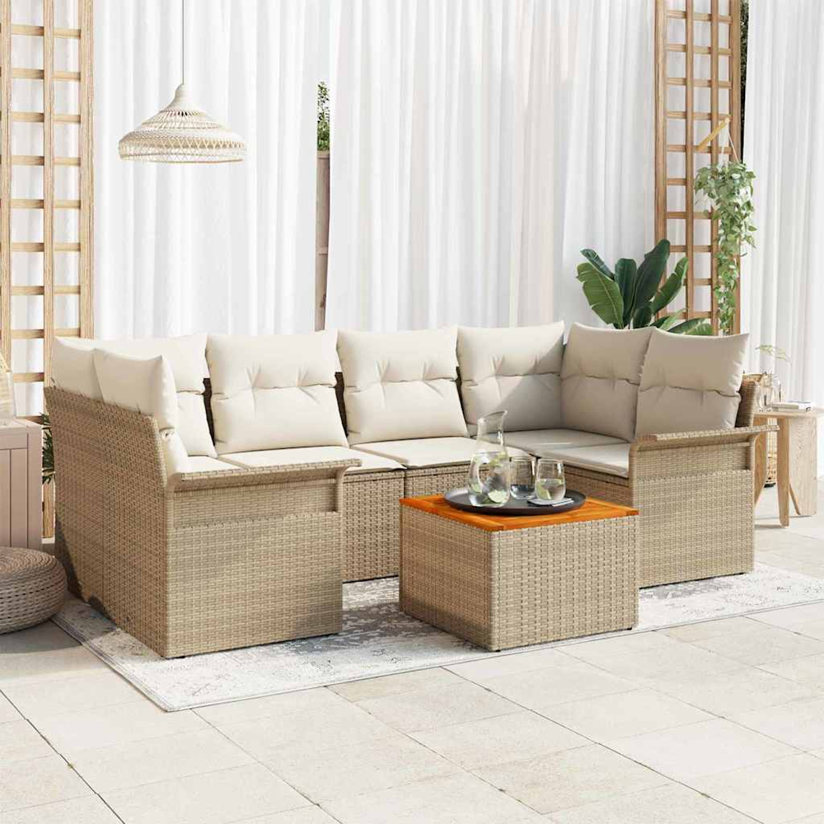Outdoor-Wicker-Ecksofa mit cremefarbenen Kissen, Couchtisch mit Gläsern, weißen Vorhängen und Hängelampe.